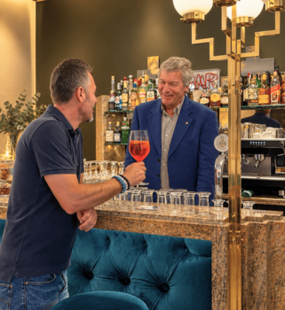 Florian Ellmenreich mit Gast an der Hotelbar im Historic South Tyrol Hotel Adria